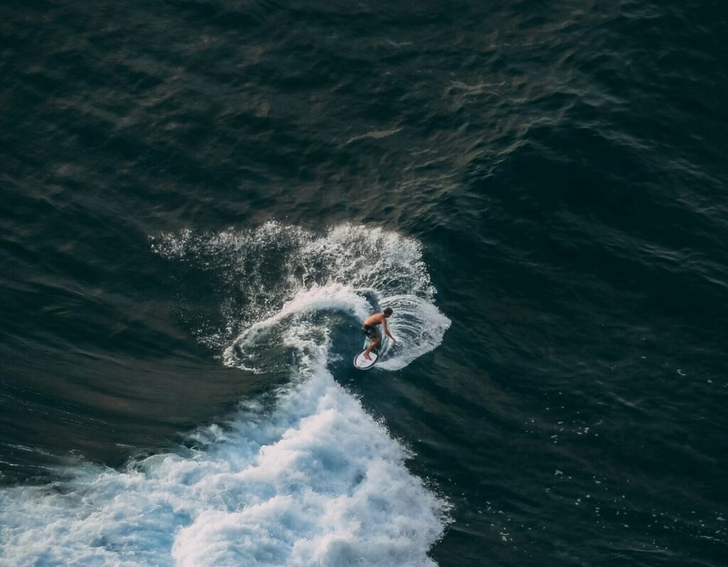 Top view of a surfer pulling a turn on a left-hand point break at La Saladita surf, Mexico