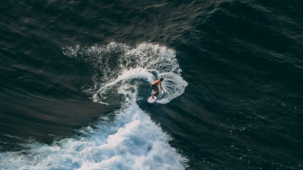 Top view of a surfer pulling a turn on a left-hand point break at La Saladita surf, Mexico