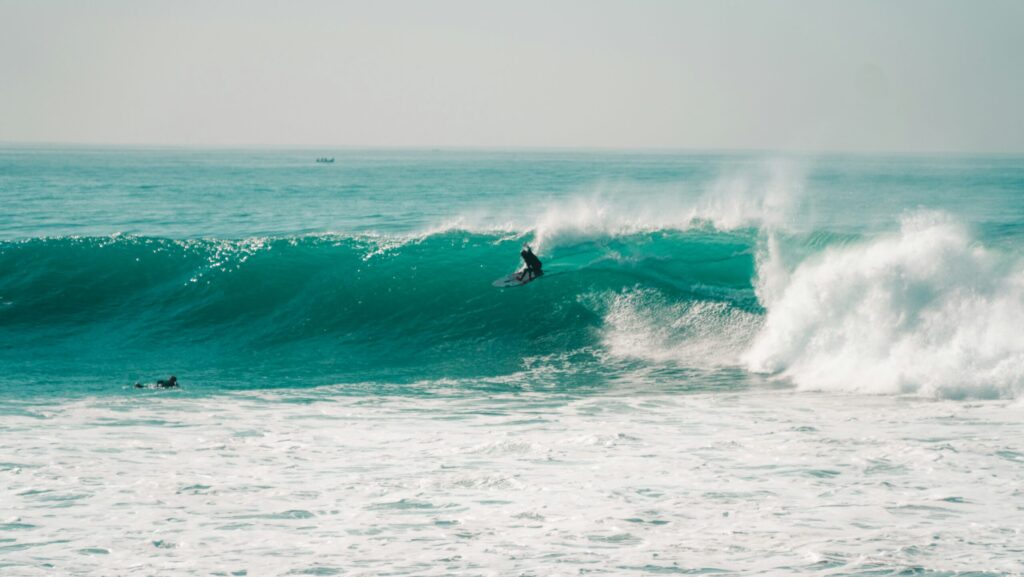 A surfer on a wave in Morocco surf in Taghzout at Killer Point doing a top turn on a massive wave