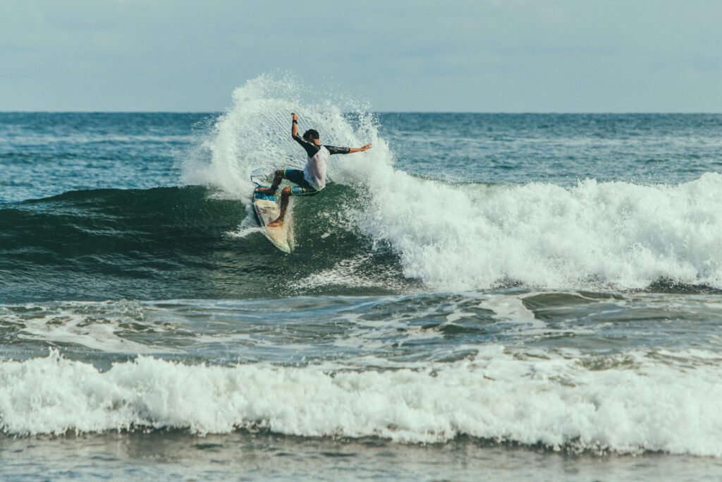 a surfer pulling a turn with lots of spray on a right hand wave in Playa las Flores surf, El Salvador