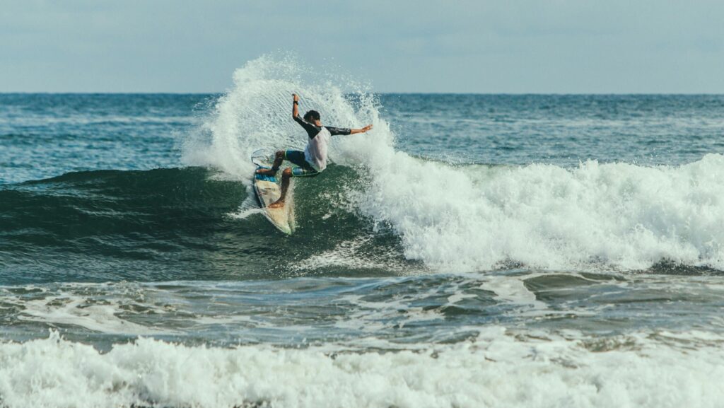 A surfer pulling a turn with lots of spray on a right hand wave in Playa las Flores surf, El Salvador