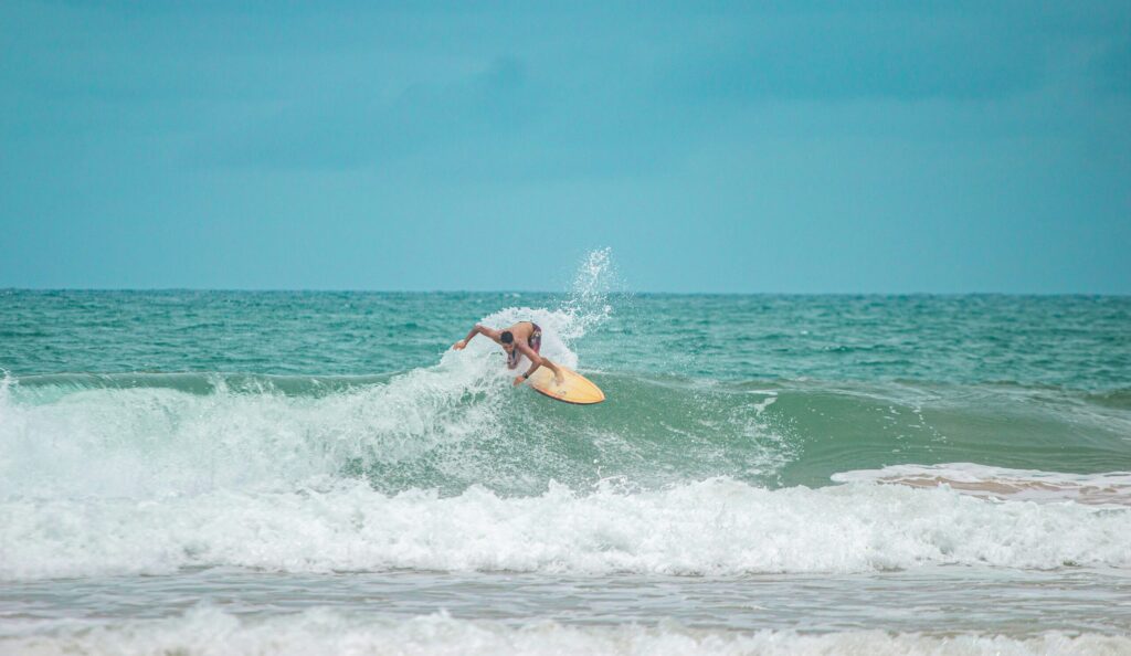 A surfer on a backhand wave doing a turn in Olon Surf Ecuador