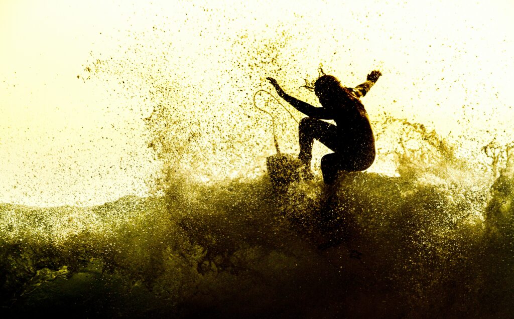 A surfer doing a top turn with yellow tinge in photo at Tarifa surf, Spain