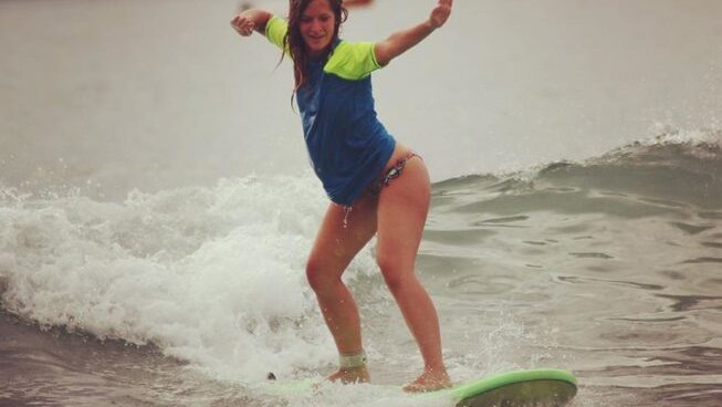 A girl learning how to surf at Tamarindo surf with La Botella de Leche Surf Camp