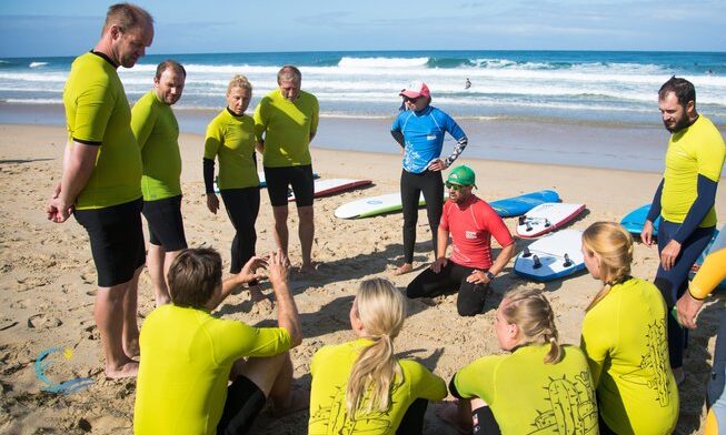 Surfers listening to an instructor with at Capbreton Surf