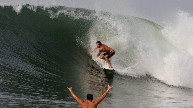 A surfer on a wave in Playa Las Flores surf in El Salvador with SurfXplore surf camp