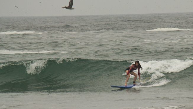 A surfer learning how to surf in Miraflores surf with Waves Surf Camp Peru
