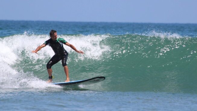 A learner surfer standing up at Mancora With Wild Kite Peru Surf Camp