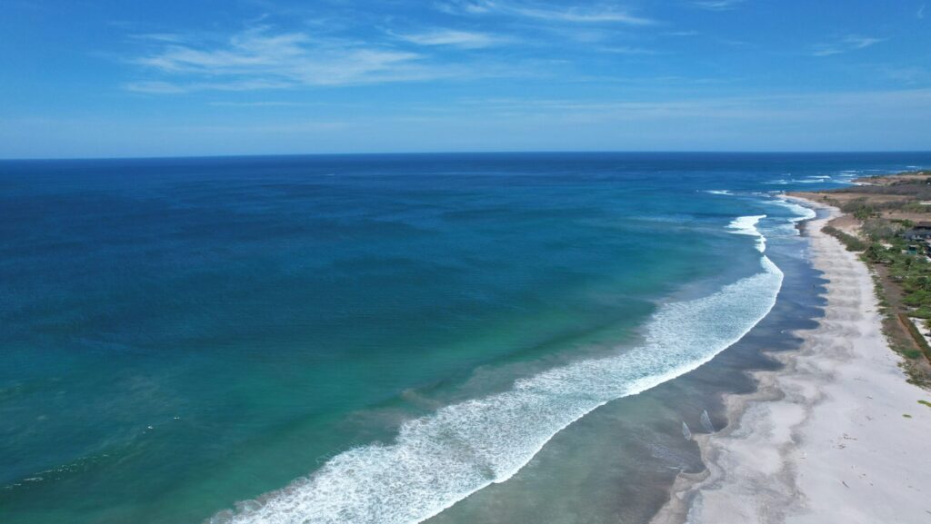 Drone shot of Tamrindo surf with blue waters