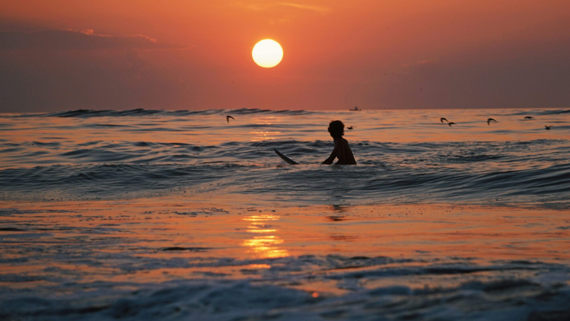 La Saladita surf with sunset and surfer in the water