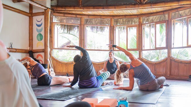 Students practicing yoga with Casa del Sol Montanita surf camp