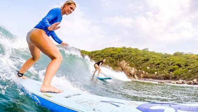 Two people on a wave learning how to surf in Puerto Escondido surf camp with Experiencia Puerto Escondido