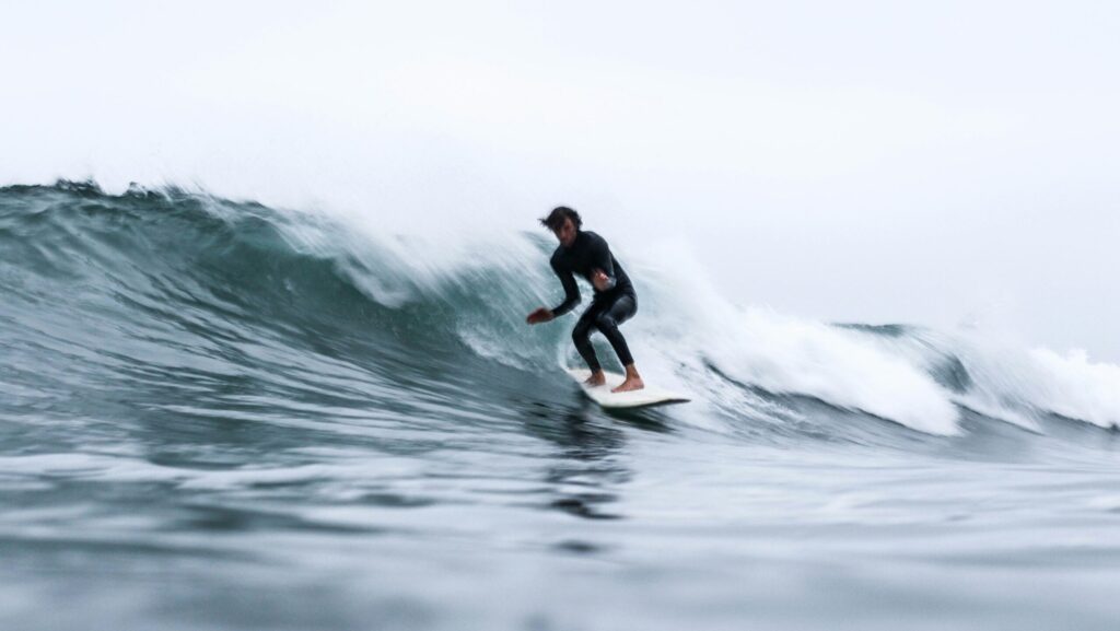 A guy surfing in Higgins Beach surf, Maine