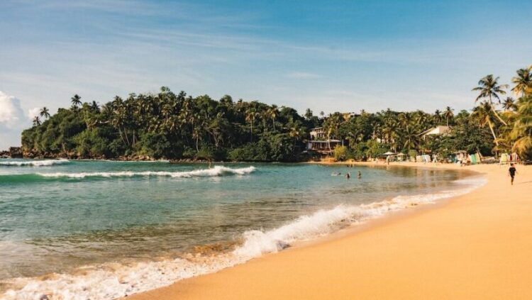 Hiriketiya surf beach in Sri Lanka with blue skies and golden sand