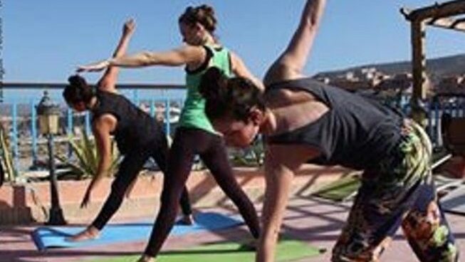 A group of girls doing yoga at Crocro Surf Maroc surf camp Agadir