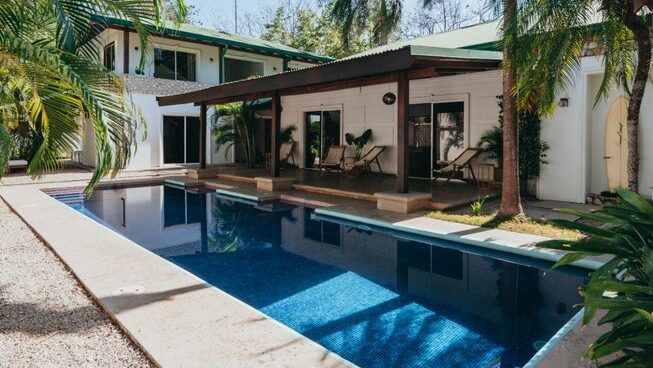 accomodation and pool with deck chairs at Dreamsea Surf House surf camp Tamarindo Costa Rica
