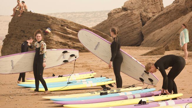 Learner surfers getting ready on the beach with Paddle Out Morocco surf camp Taghazout surf and yoga retreat