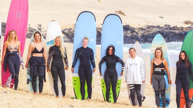 A group of surfers standing with their surfboards at Salty Chicas surf camp
