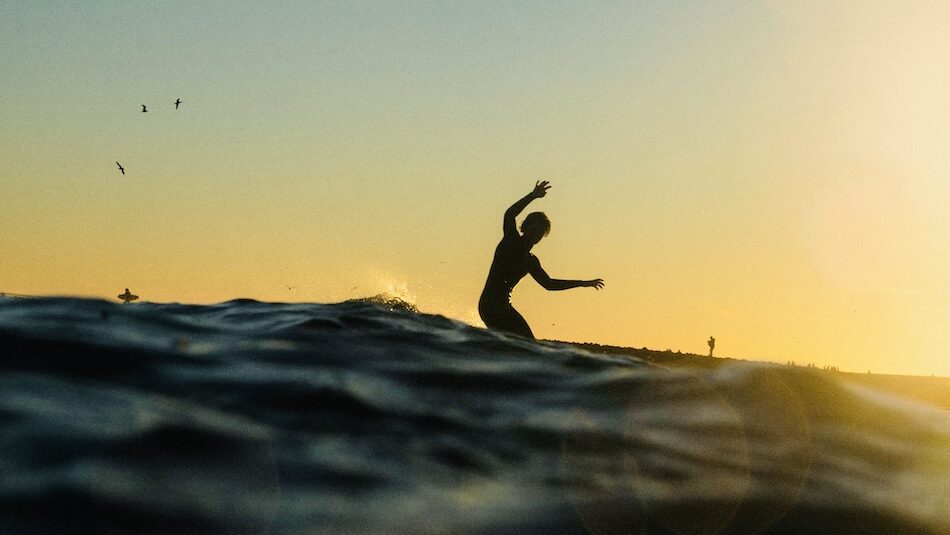 A guy on a surfboard at sunset at Surf Camp Agadir