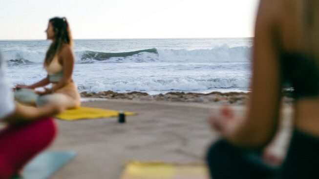 Students doing yoga on the beach with Yoga Surf Retreat Portugal Algarve