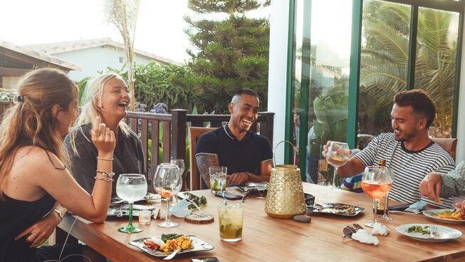 A group of people hanging around a table at Surfescape Fuerteventura in an all inclusive surf camp Canary Islands