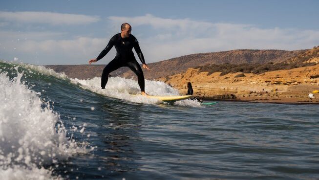 A learner surf catching a wave at The Surf hotel Morocco Surf Camp