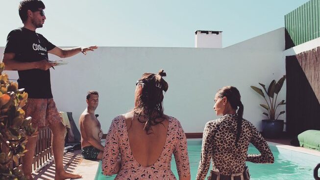 people sitting around a pool at Peniche Portugal with Ahoy Surf House surf camp