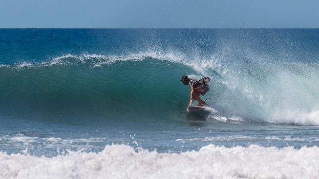 a guy in a barrel wave at Akih Pods Hostel in Santa Teresa