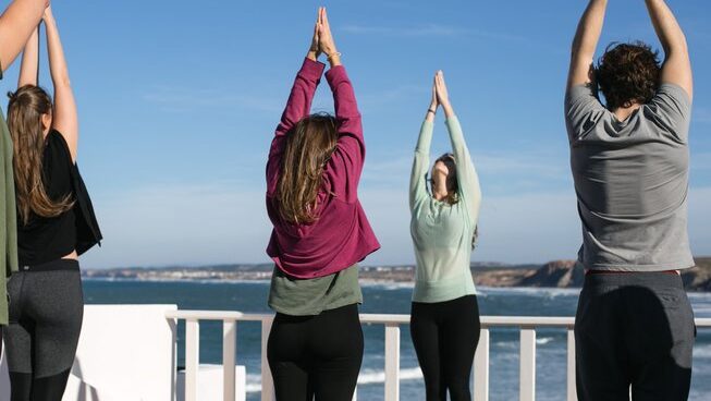 people doing yoga on the rooftop at Balili Beach House surf camp in Peniche Porutgal
