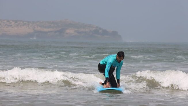 a learner surfer trying to stand up at Bleuryde Watersports surf camp in Essaouira Morocco