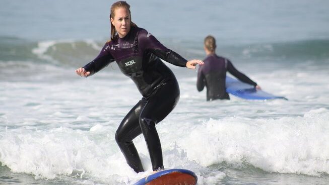 A learner surfer standing on a wave at Breath surf Camp in Agadir
