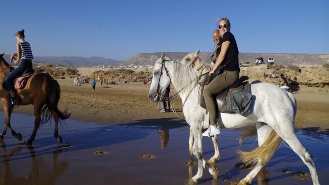 Girls riding a horse with blue skies at Breath surf Camp in Agadir