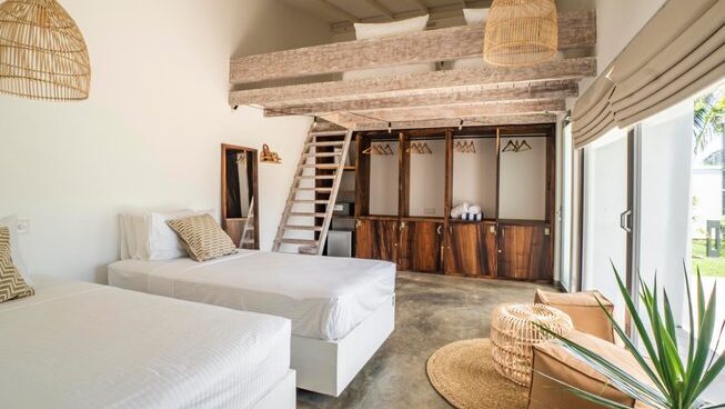 accommodation with beds and upstairs area at Global Surf Lodge Kabalana Surf Camp
