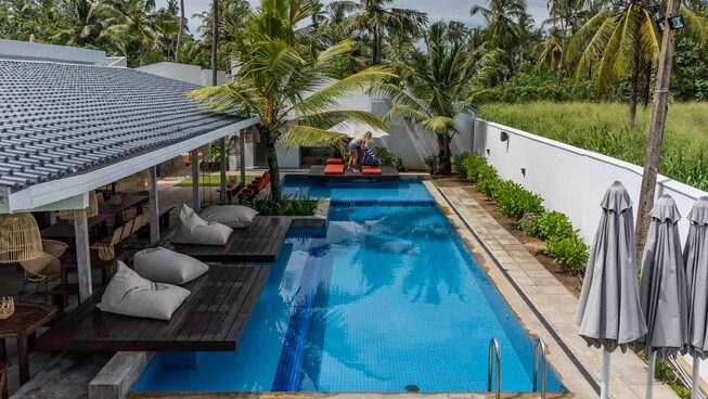 accommodation with pool and sun beds at Global Surf Lodge Kabalana Surf Camp