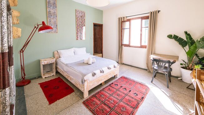 Accommodation room with bed and windows at Loving Surf Essaouira Surf Camp Morocco