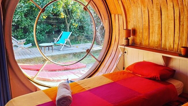 Accommodation and bed with window at Maceda Surf Camp in Porto Portugal