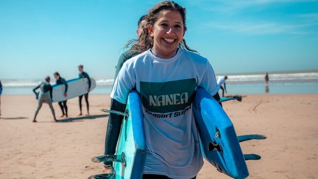 Two surfers carrying surfboards together at Naneakite Surf Camp in Essaouira Morocco