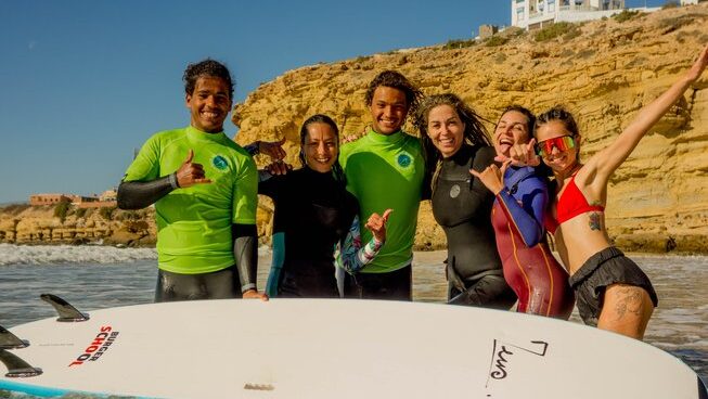 A group of surfers posing in the ocean at Olas Surf Ltd Imsouane surf camp