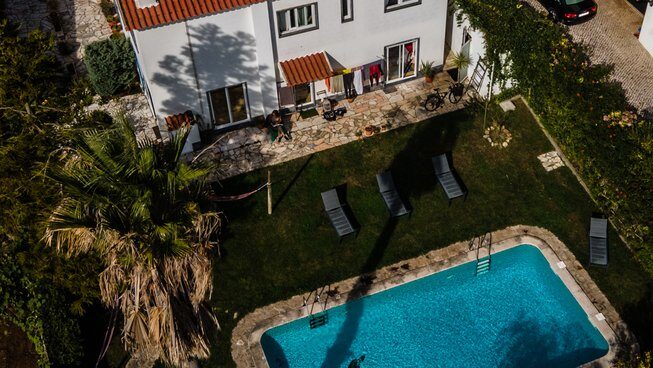 Drone shot of a pool and accommodation building at Omassim surf camp in Ericeira Portugal