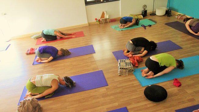 people in a yoga pose at Omassim surf camp in Ericeira