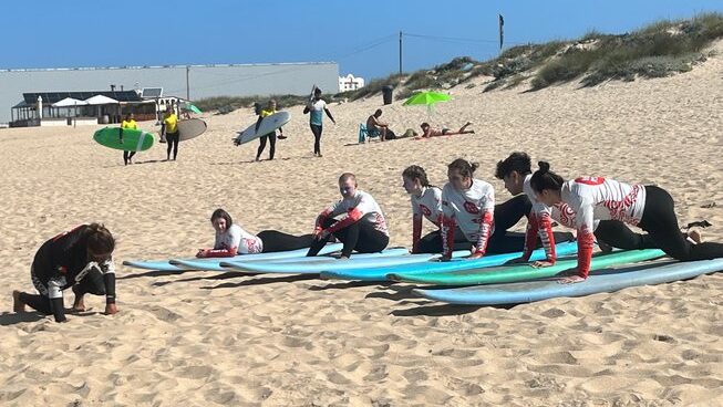 learner surfers practicing standing up on the sand with Peniche with Peniche surf lodge surf camp
