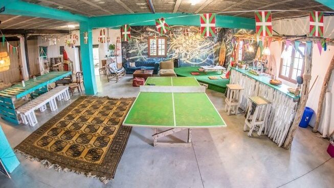 Accommodation with ping pong table and couches at San Sebastian Surf Camp