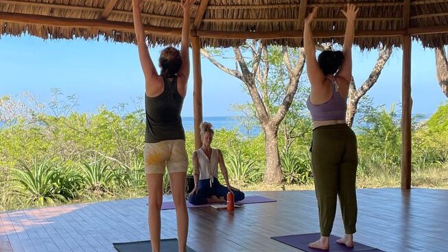 People in a yoga pose at Shambala Retreats surf camp Nosara, Costa Rica