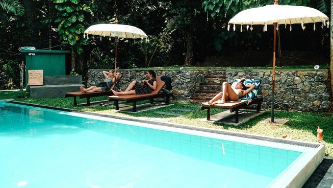 People sitting by the pool at Surf & Yoga Mirissa surf retreat