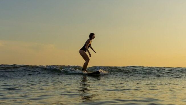 A surfer with low light and yellow background at Surf & Yoga Mirissa surf retreat