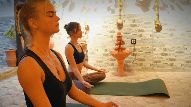 two girls practicing yoga at The Petit Surfer Imsouane surf camp