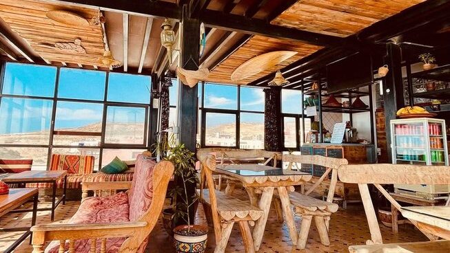 closed in balcony with chairs and benches at The Petit Surfer Imsouane surf camp
