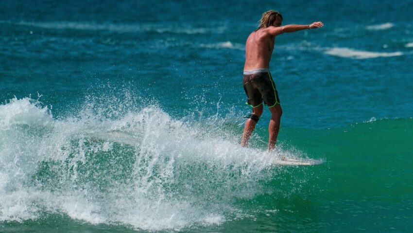 a guy surfing on a wave at an all inclusive Sri Lanka surf camp