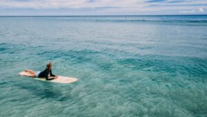 A surfer sitting in the blue water at a best Costa Rica surf camp for beginners