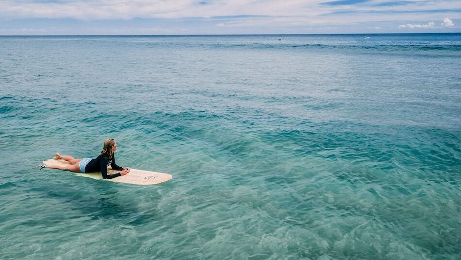 A surfer sitting in the blue water at a best Costa Rica surf camp for beginners